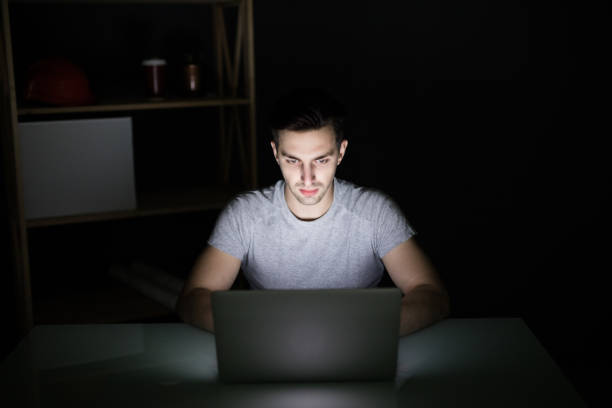istock Architect sitting at night working on architectural plan on laptop. Young interior designer in casual checking blueprint of a house on laptop. Architect studying the map and layout of a new project. 862026642
