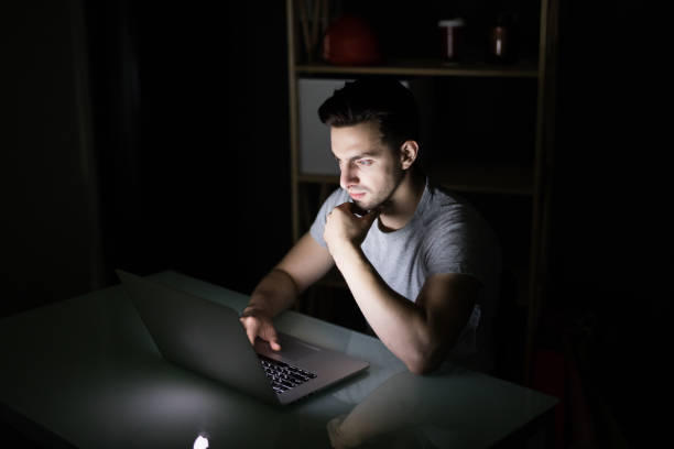 istock Late night internet addiction or working late man using laptop at a desk in the dark 862026772