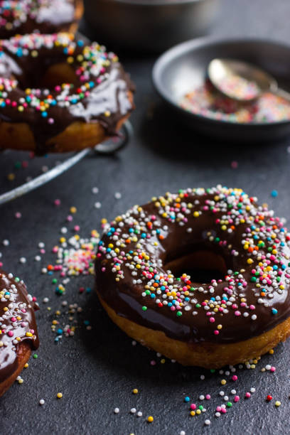 istock fresh chocolate donuts with chocolate glaze  and colorful sprinkles on dark background 862029792