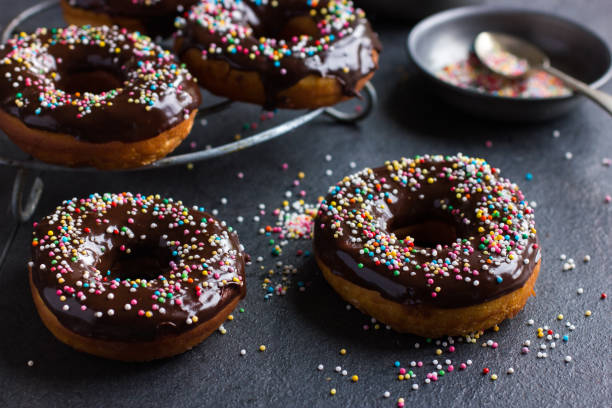 istock fresh chocolate donuts with chocolate glaze  and colorful sprinkles on dark background 862029794