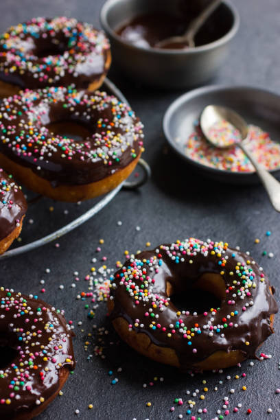 istock fresh chocolate donuts with chocolate glaze  and colorful sprinkles on dark background 862029798