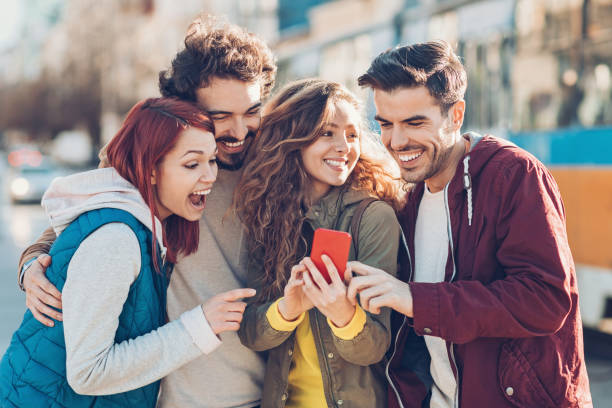Group of young people watching at a smart phone and laughing