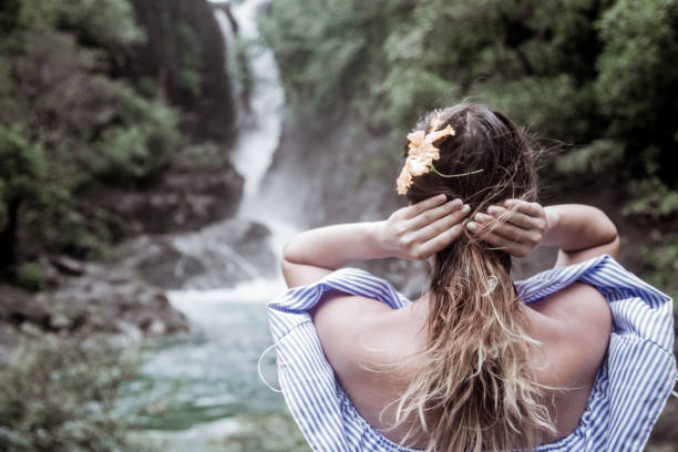 istock the girl looks at the waterfall back 862034418