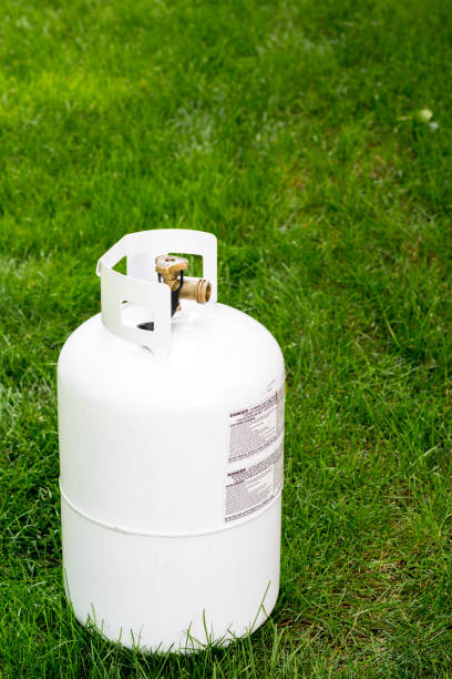 istock Single propane bottle sitting in the grass with warning labels 862034484