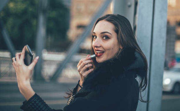 istock Girl putting lipstick on lips 862040258