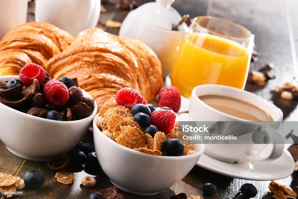 Breakfast served with coffee, juice, croissants and fruits Breakfast served with coffee, orange juice, croissants, cereals and fruits. Balanced diet. Breakfast Stock Photo