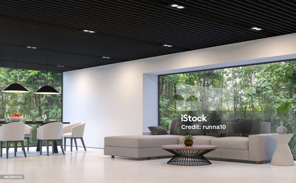 Modern black and white living room and dining room with forest view 3d rendering image Modern black and white living room and dining room with forest view 3d rendering image.There are white floor and wall,black steel ceiling.There are large window overlooking to nature Living Room Stock Photo