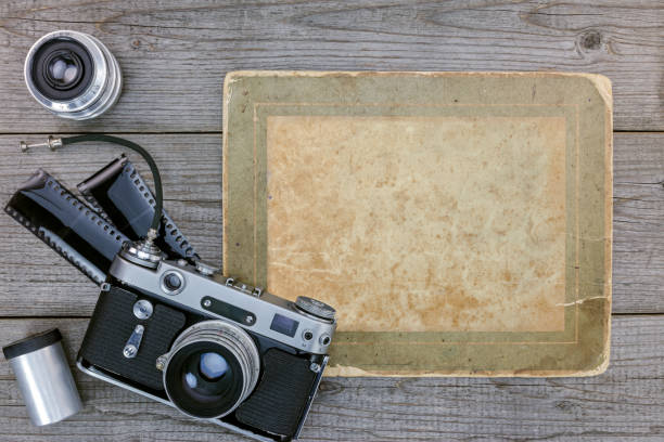 istock retro camera, negative film, lenses on wooden table background 862057596