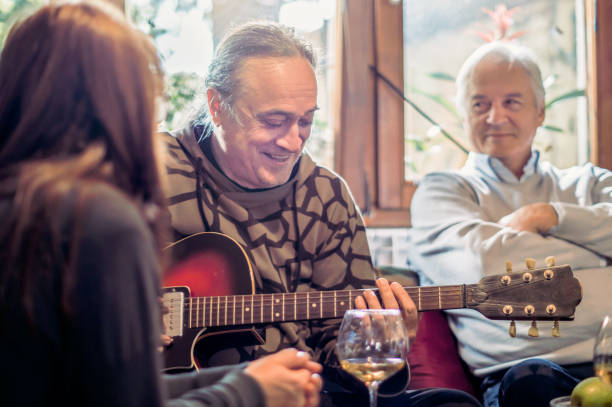 istock Senior man singing and playing guitar for his friends 862065730