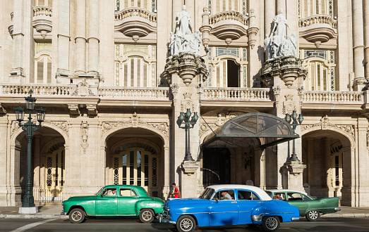 Havana: American green and blue white Chevrolet Buick and Dodge vintage car drive before the gran teatro on the main street in Havana City Cuba - Serie Cuba Reportage