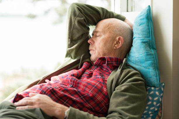istock Senior male rests with eyes closed on window seat 862085928