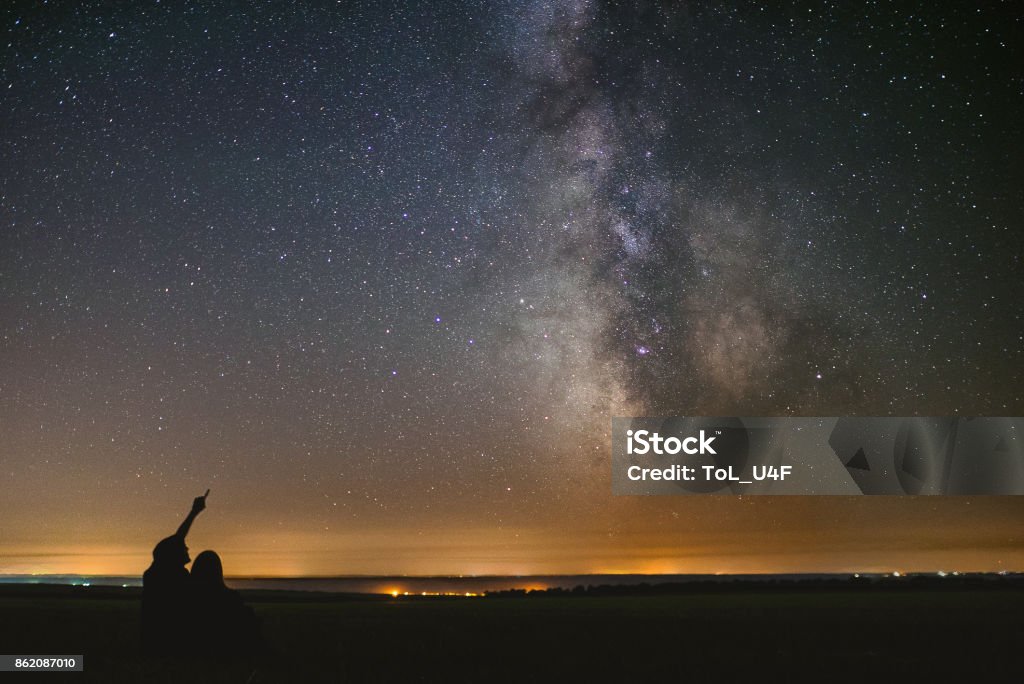 Home away from Home couple in love under stars of center our home galaxy Milky Way. Two people at night under stars Astronomy Stock Photo