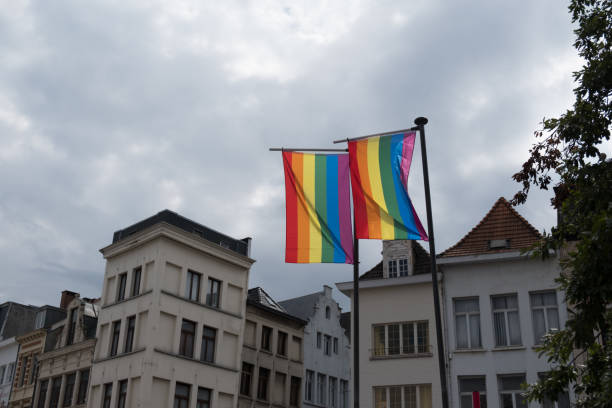 Two LGBT rainbow flags on flagpoles blowing in the wind on a cloudy day in Antwerp Belgium. Gay rainbow flags from a gay pride festival in Antwerpen. Two LGBT rainbow flags on flagpoles blowing in the wind on a cloudy day in Antwerp Belgium. Gay rainbow flags from a gay pride festival in Antwerpen. aon center chicago photos stock pictures, royalty-free photos & images