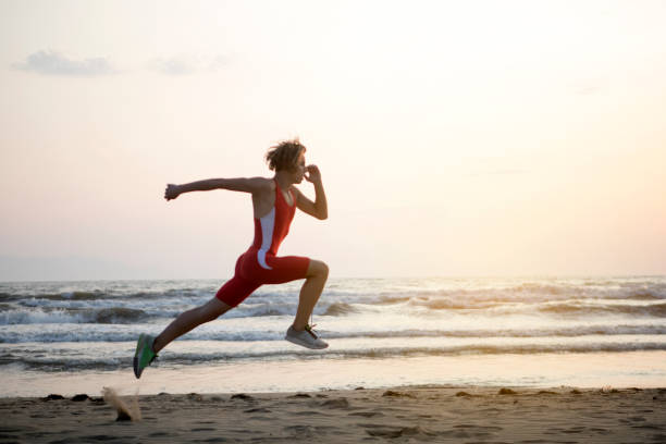 Youn Man Running At Beach Athlete exercising pentathlon stock pictures, royalty-free photos & images