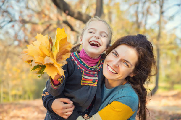 istock Mother and daughter playing in autumn park 862097300