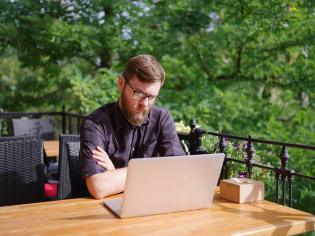 istock Goodly young man working on laptop while sitting outdoors . Business concept. 862110650