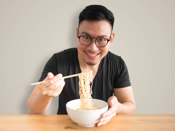 istock Happy man eating instant noodles. 862111426