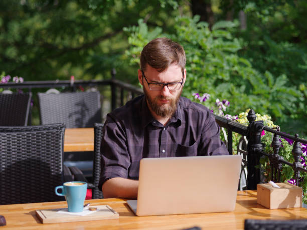istock Goodly young man working on laptop while sitting outdoors . Business concept. 862111670