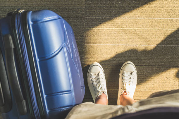 istock Aerial view,Looking down at white sneaker and travel suitcase with morning sunlight through window at airport terminal,Vacation concept 862112074
