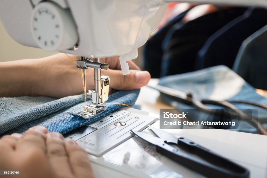 mano delle donne che lavorano sulla macchina da cucire - Foto stock royalty-free di Cucire