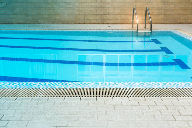 istock Indoor blue swimming pool with grating between grey tile and mosaic floor for background. 862120692