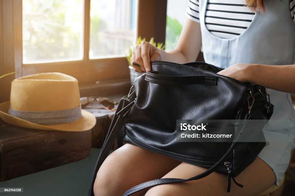 Junge Frau auf der Suche nach etwas in ihrem Geldbeutel - Lizenzfrei Tragebehältnis Stock-Foto
