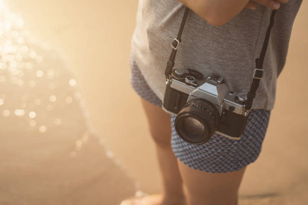 istock Young woman traveller with retro camera on the beach 862146164