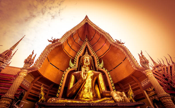 Golden Buddha statue decorated with mosaic inside the semi-circular dome named "Chin Prathanporn" situated in outdoor area of Wat Tham Sua(Tiger Cave Temple),Tha Muang District,Kanchanaburi,Thailand. Wat Tham Sua (Tiger Cave Temple) is located at the hill top of Tha Muang District,Kanchanaburi Province,Thailand.Large golden Buddha image decorated with mosaic inside the semi-circular dome named "Chin Prathanporn" is situated in outdoor area.Visitors usually make respect here before move up to respect holy relics at octagonal pagoda named "Ketkaew Prasat Chedi" and see panoramic view there.The view is really outstanding with Mae Klong River and green color of gigantic rice fields. Visitors are able to see Chinese Pagoda of Wat Tham Khao Noi located next to this temple. wat tham sua stock pictures, royalty-free photos & images