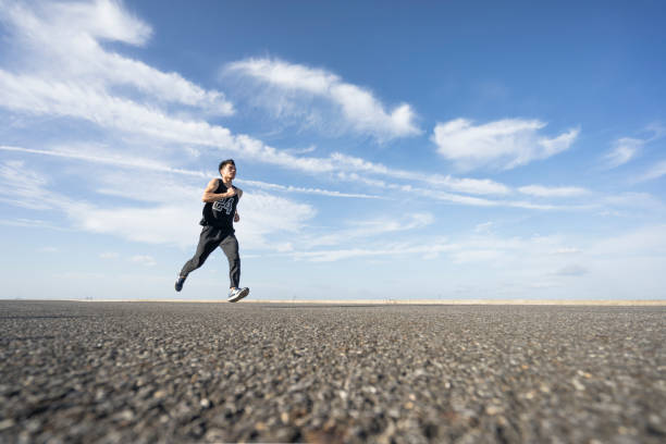 istock young male runner running on asphalt road against sky 862160752