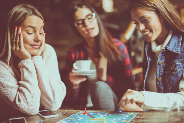 istock Three happy girls playing board game. 862161222