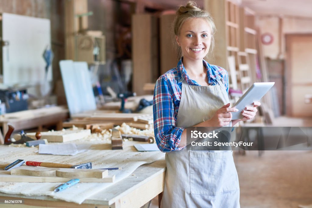 Joven carpintero con tableta Digital en la tienda de madera - Foto de stock de Artesano libre de derechos