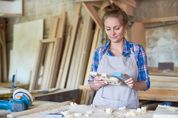 istock Female Carpenter Sanding Wooden Part in Workshop 862161388