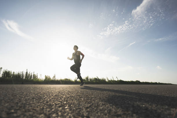 istock young male runner running on asphalt road against sky 862163642