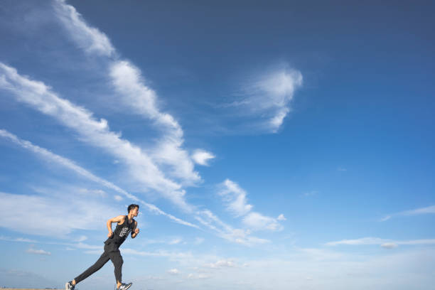 istock young male runner running on asphalt road against sky 862163784