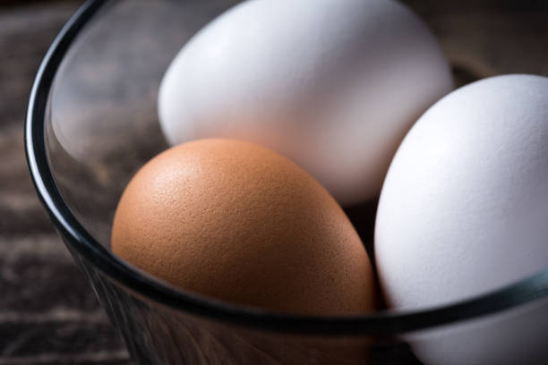 istock Organic Brown Egg with 2 White Eggs in a Bowl 862164084