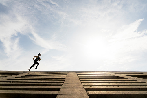 low angel view of energetic athlete running against sky.