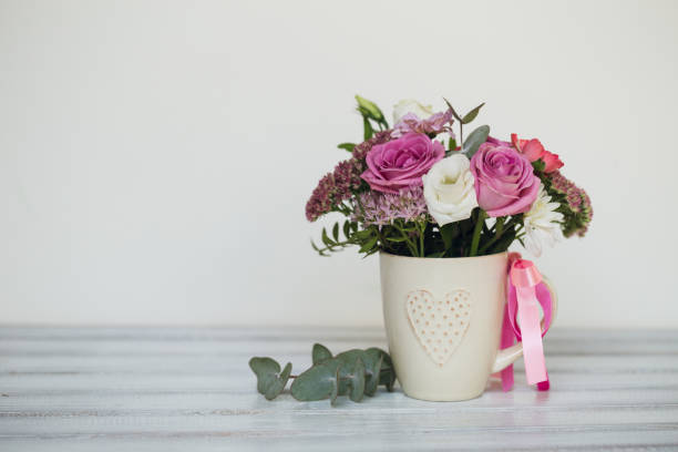 istock Beautiful flowers in cup on wooden background 862179442