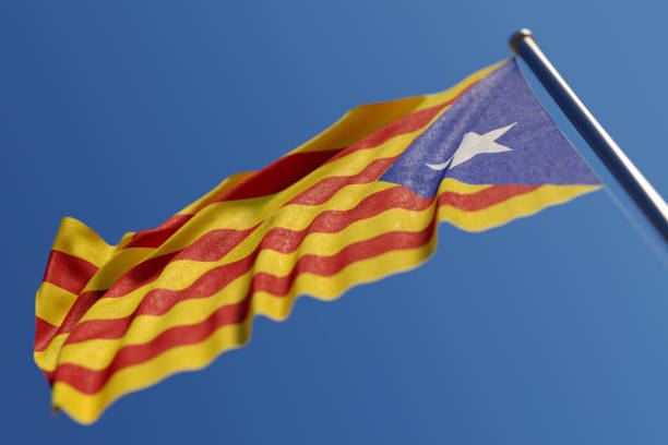 High quality 3d render of Catalan Estelada flag waving with wind on a blue sky. Low angle view with copy space and selective focus. Great use for Catalan politics and Catalan culture related concepts. Horizontal composition.
