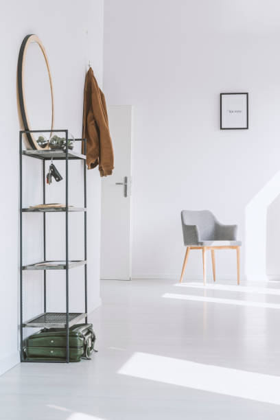 Bright apartment with white walls Simple gray armchair standing near the entrance to a bright apartment with white walls key doormat stock pictures, royalty-free photos & images
