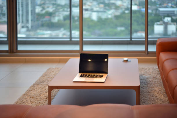 istock Laptop on table in modern living room with blank screen 862184750