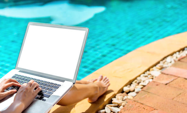 Woman bikini using laptop computer blank screen at swimming pool in resort edge, Close up hand