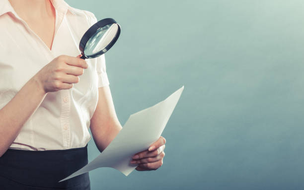 istock woman uses magnifying glass to check contract 862197412