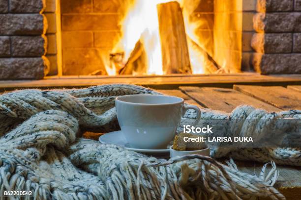 Cup Of Tea And Sugar Woolen Things Near Cozy Fireplace Stock Photo - Download Image Now