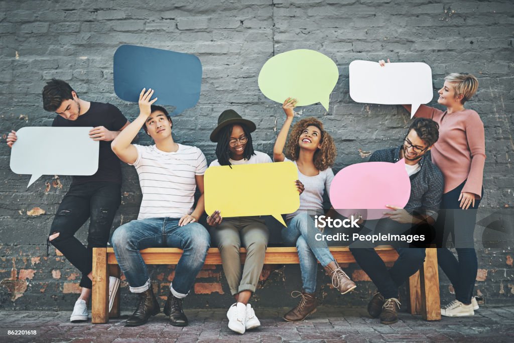 If you want to say something, say it here Shot of a diverse group of people holding up speech bubbles outside Discussion Stock Photo