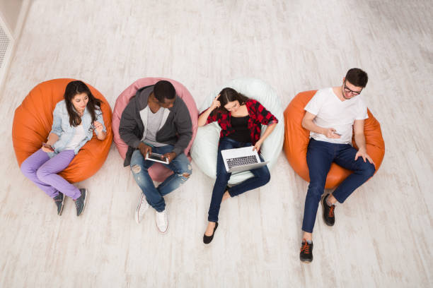 istock Friends using gadgets, sitting indoors in line 862205778