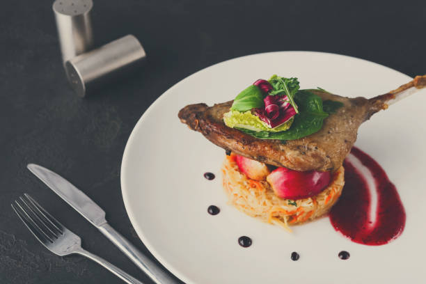 istock Restaurant meals. Duck confit with vegetables on black backgroun 862212192