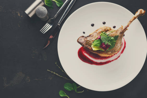 istock Restaurant meals. Duck confit with vegetables on black backgroun 862212260