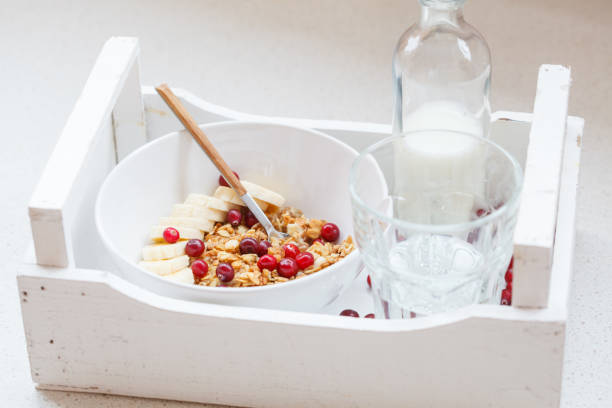 Muesli with banana and berries for breakfast in a white wooden box, healthy breakfast concept.