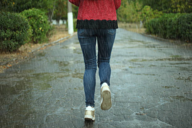 istock girl runs through puddles in the rain 862216864