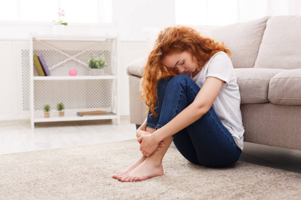 istock Sad redhead woman thinking on the floor at home 862229998